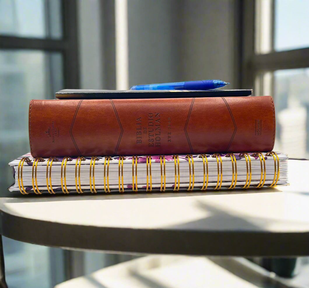 Stack of books and notebooks on a table with a blurred background