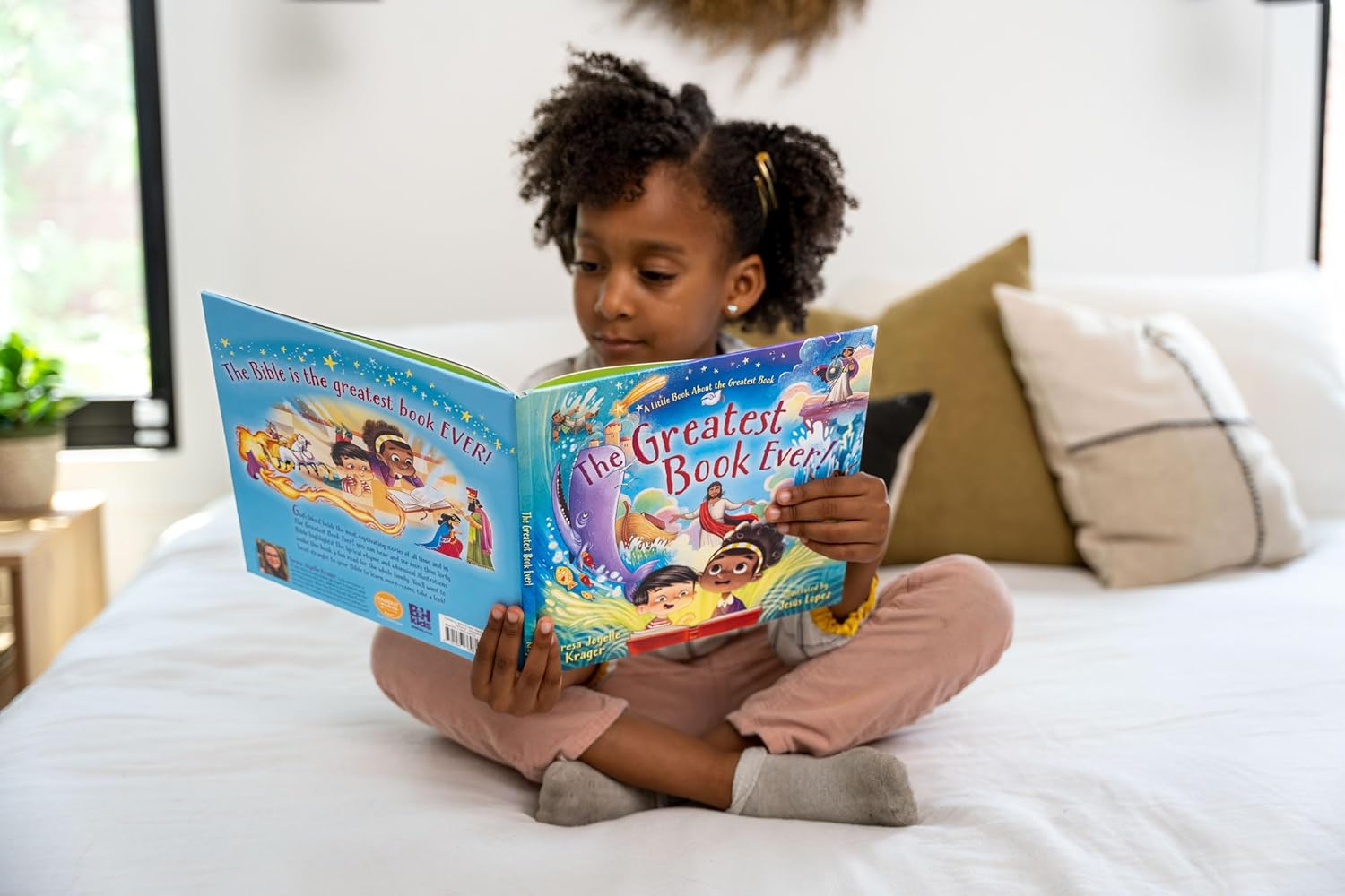 The Greatest Book Ever – Children’s Bible Storybook Hardcover | Ages 4–8. Child reading a Disney book on a bed