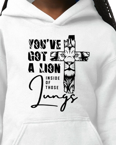 White hoodie with a graphic of a lion and cross design, text 'You've got a lion inside those lungs', and black border.